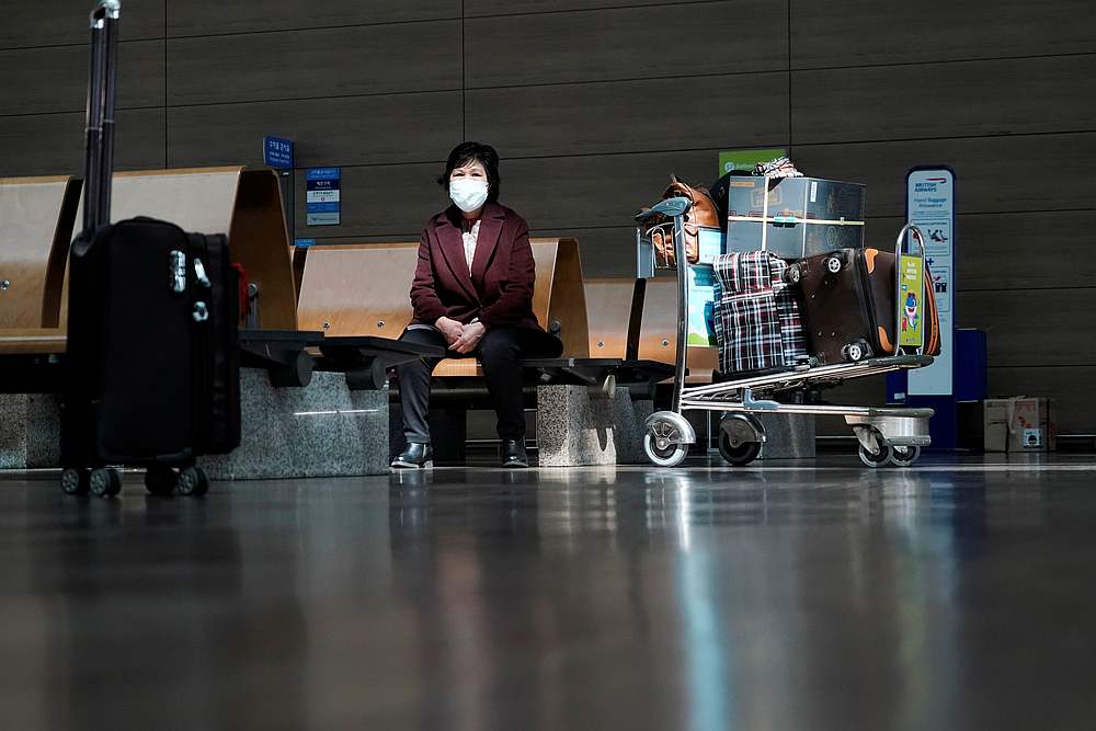 A woman wearing a mask to prevent contracting Covid-19 waits for her flight at Incheon International Airport in South Korea March 19, 2020. u00e2u20acu201d Reuters