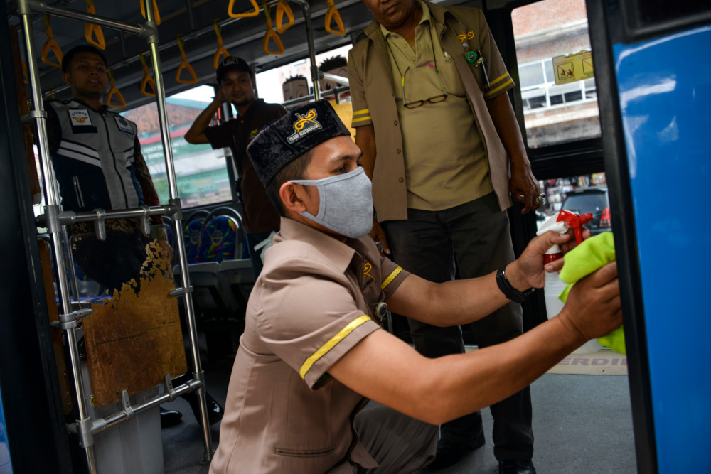 A worker sprays disinfectant on a bus as part of preventive measures against the spread of the Covid-19, in Banda Aceh March 5, 2020. u00e2u20acu201d AFP pic 
