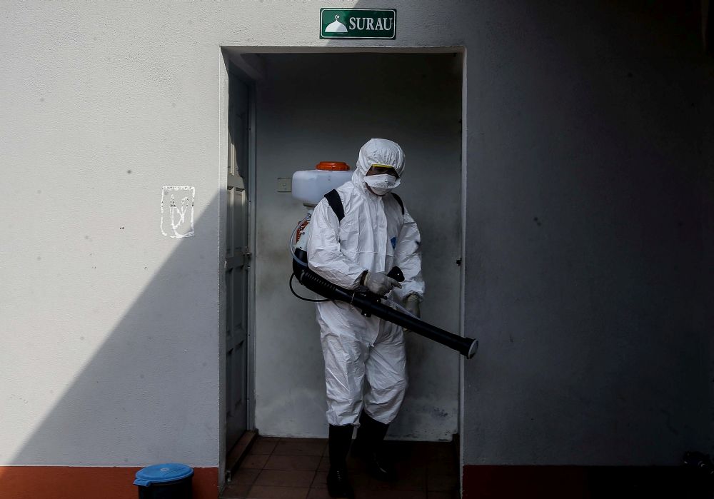 A city council worker sprays disinfectant at an eatery in Bazaar Medan Kidd to prevent the spread of Covid-19 in Ipoh March 25, 2020. u00e2u20acu201d Picture by Farhan Najib