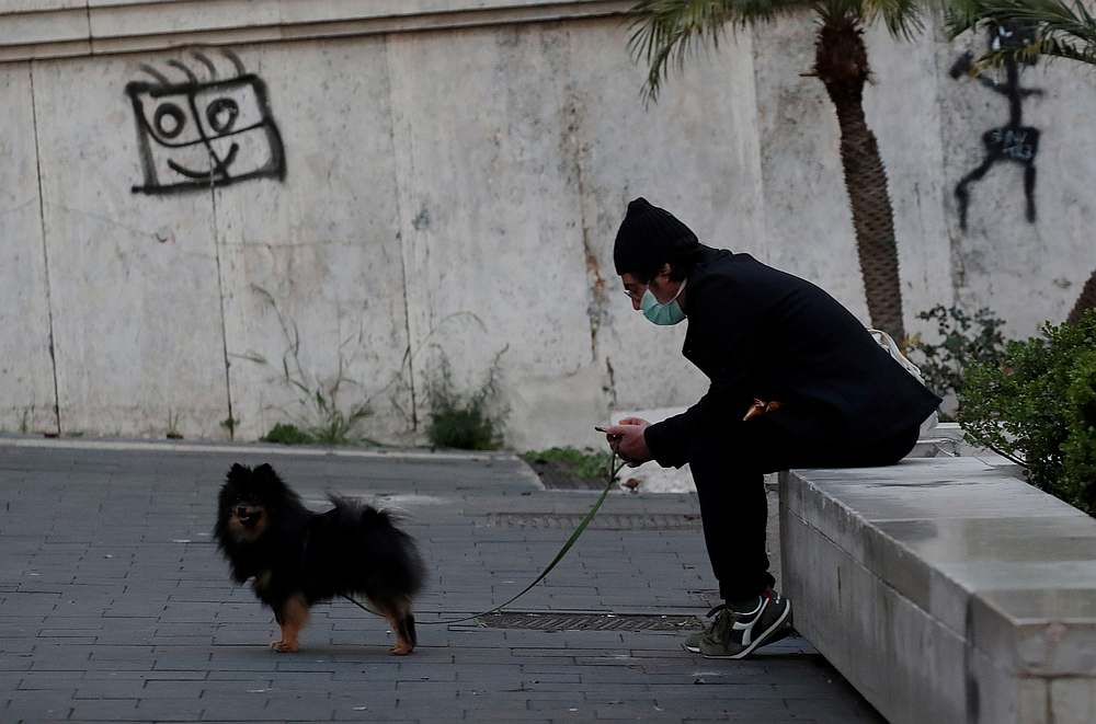 A man wearing a mask with his dog as Italy remains under a nationwide lockdown in a government decree that orders Italians to stay at home, Naples, Italy March 19, 2020. u00e2u20acu201d Reuters pic