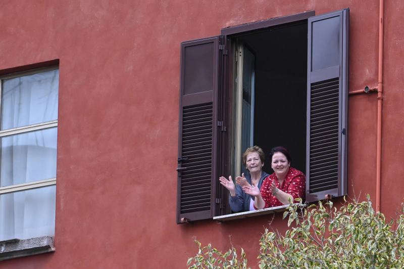 People wave and clap their hands during a flash mob u00e2u20acu02dcUn applauso per l'Italiau00e2u20acu2122 (An applause for Italy) at the Garbatella district in Rome. u00e2u20acu2022 AFP pic