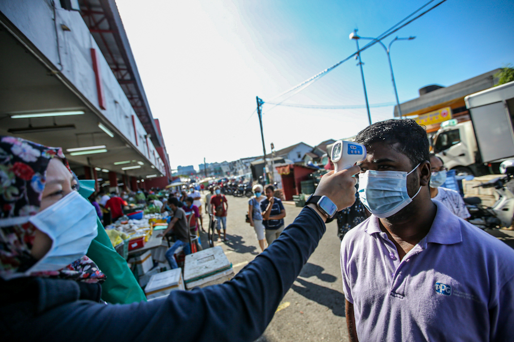 Members of the public are screened as they queue outside Pasar Besar Jalan Othman in Petaling Jaya March 26, 2020. — Picture by Hari Anggara