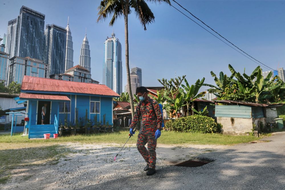 A Fire and Rescue personnel sprays disinfectant in Kampung Baru to curb spread of Covid-19 in Kuala Lumpur March 31, 2020. u00e2u20acu201d Picture by Ahmad Zamzahuri