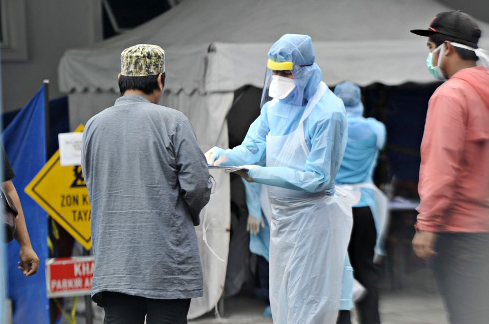 Government health workers attend to members of the public at the Kuala Lumpur Health Clinic March 24, 2020. — Picture by Shafwan Zaidon
