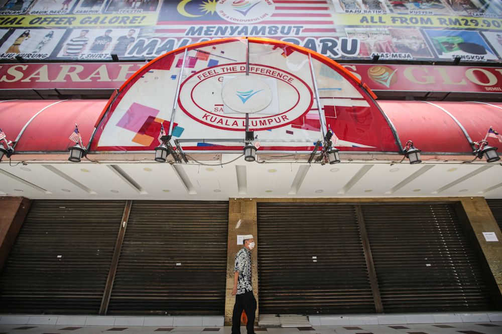 A man walks past shuttered shops along Jalan Tuanku Abdul Rahman as the movement control order kicks in on March 18, 2020. u00e2u20acu201d Picture by Hari Anggara