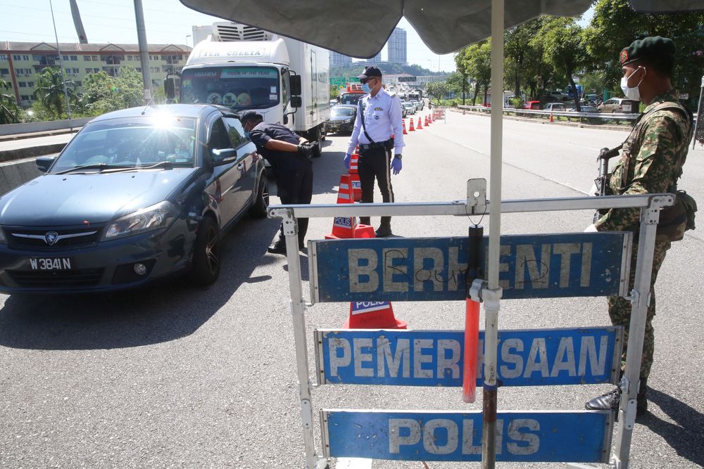 Malaysian Armed Forces and police personnel man a roadblock amid heavy traffic along the LDP in Petaling Jaya on March 25, 2020. u00e2u20acu201d Picture by Choo Choy May