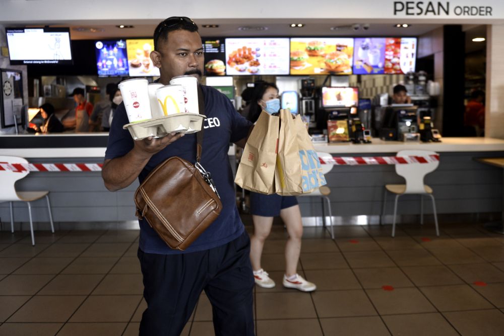 A GrabFood rider picks up his order at a McDonaldu00e2u20acu2122s outlet in Bangsar as the movement control order kicks in on March 18, 2020. u00e2u20acu201d Picture by Miera Zulyana