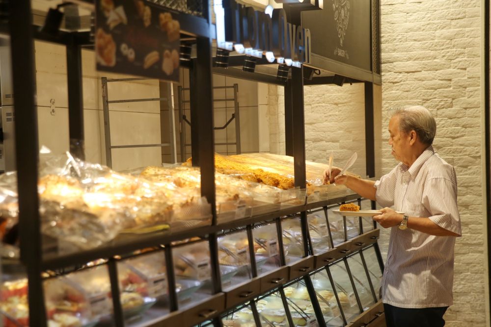 A man looks at the confections on offer at a bakery in the Mid Valley shopping mall March 18, 2020. — Picture by Choo Choy May