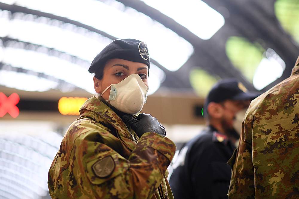 A military member looks on as police checks on people at Milan's main train station to stem Italy's coronavirus contagion March 9, 2020. u00e2u20acu201d Reuters pic