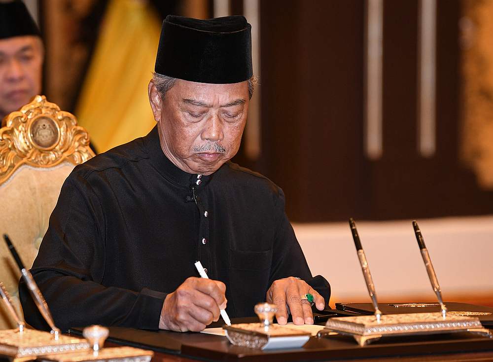 Bersatu president Tan Sri Muhyiddin Yassin signs a letter of appointment at a ceremony in Istana Negara, Kuala Lumpur March 1, 2020. u00e2u20acu201d Bernama pic