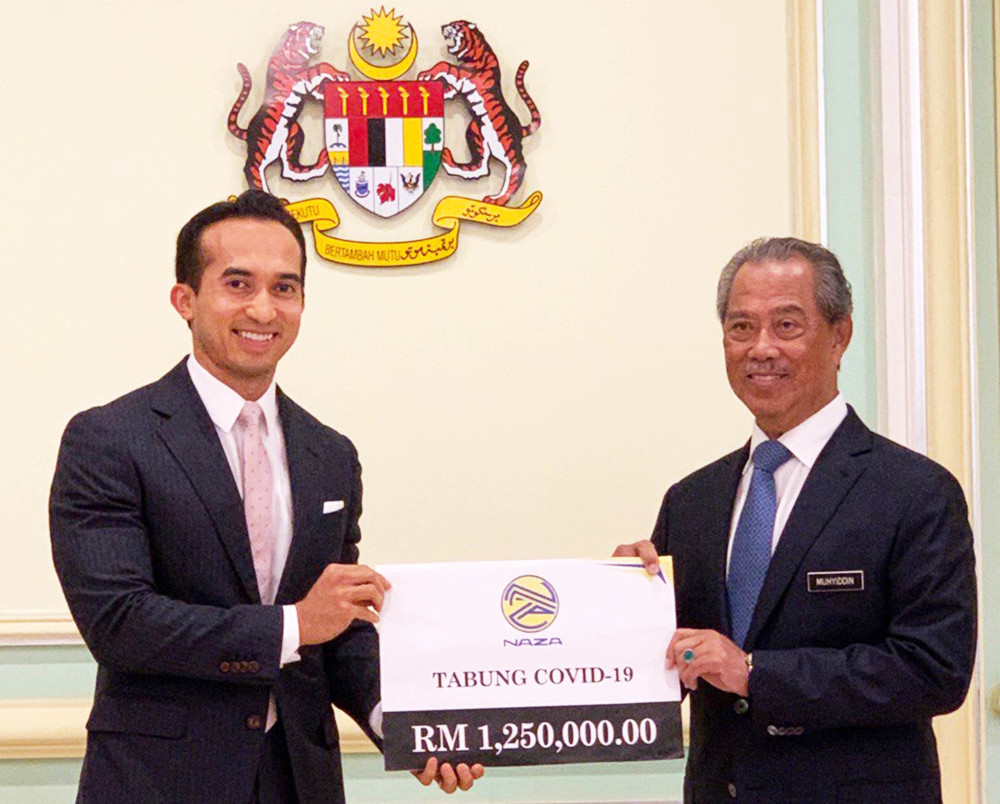 Naza Corporation Holdings Group Executive Chairman and CEO SM Nasarudin SM Nasimuddin presents the mock cheque for the Covid-19 fund to Prime Minister Tan Sri Muhyiddin Yassin in Putrajaya March 30, 2020. u00e2u20acu201d Picture courtesy of Naza Corp