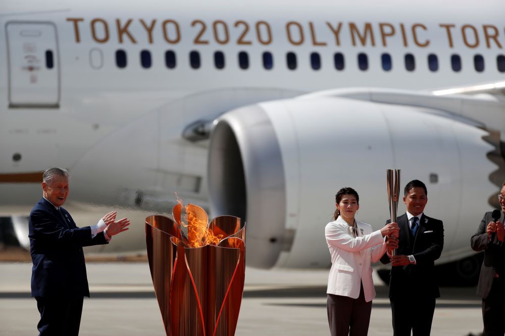 Three-time Olympic gold medalists Tadahiro Nomura and Saori Yoshida pose after lighting the Olympic flame at the Olympic cauldron while watched by Tokyo 2020 Olympics President Yoshiro Mori (left) in Miyagi March 20, 2020. u00e2u20acu201d Reuters pic