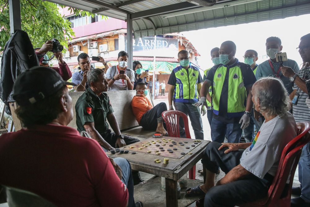 Police personnel speak to members of the public during Ops Covid-19 in Klang March 19, 2020. u00e2u20acu201d Picture by Yusof Mat Isa