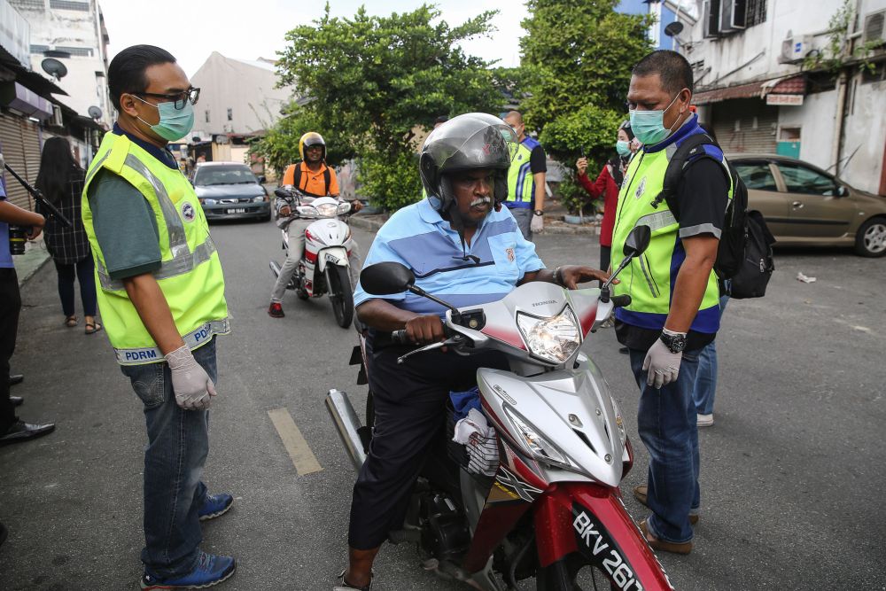 Police personnel speak to members of the public during Ops Covid-19 in Klang March 19, 2020. u00e2u20acu201d Picture by Yusof Mat Isa