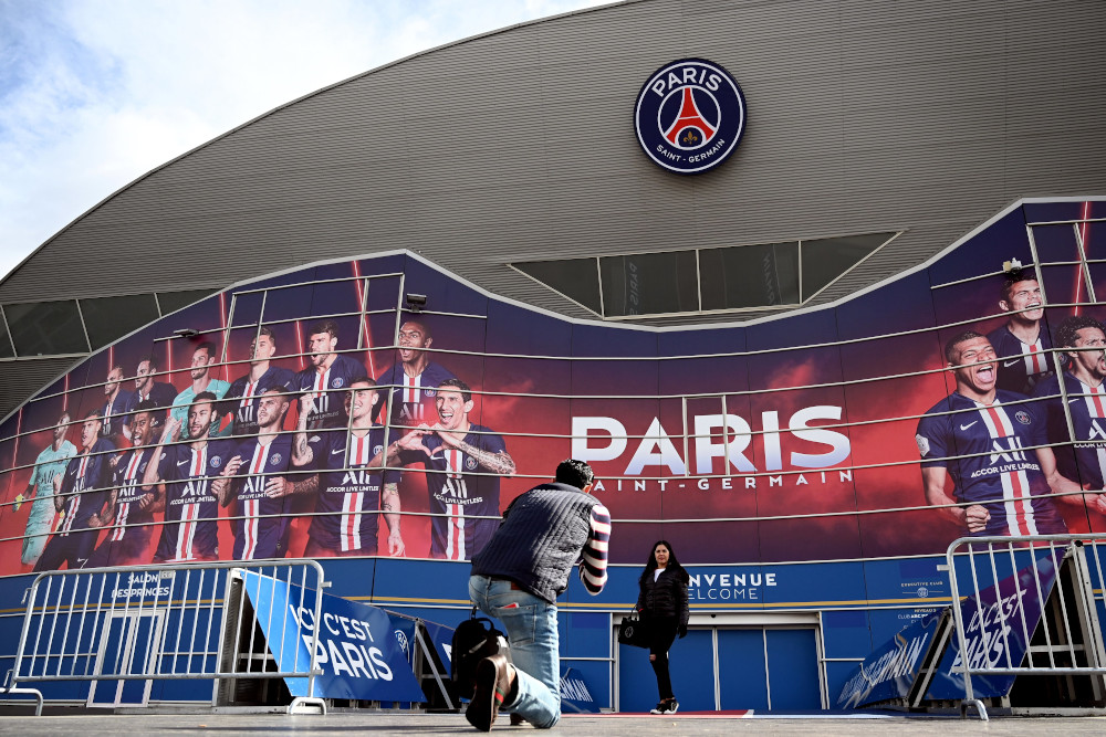 People pose for photographs in front of the Parc des Princes stadium in Paris, March 9, 2020 two days ahead of the Uefa Champions League Group A football match between Paris Saint-Germain (PSG) and Dortmund. u00e2u20acu201d AFP pic  