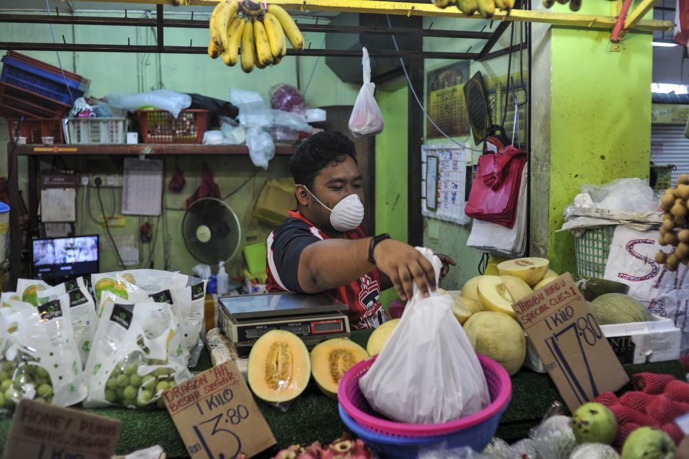 Fruit stall operator Khairul Anwar Salehuddin, 23, says some customers have taken to calling his business and asking if home deliveries can be made. — Picture by Shafwan Zaidon 