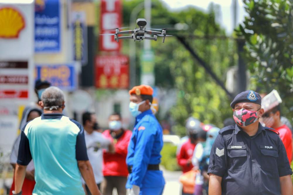 A drone is used by Malaysian police to monitor social distancing at the Chow Kit market in Kuala Lumpur March 27, 2020. u00e2u20acu2022 Picture by Ahmad Zamzahuri