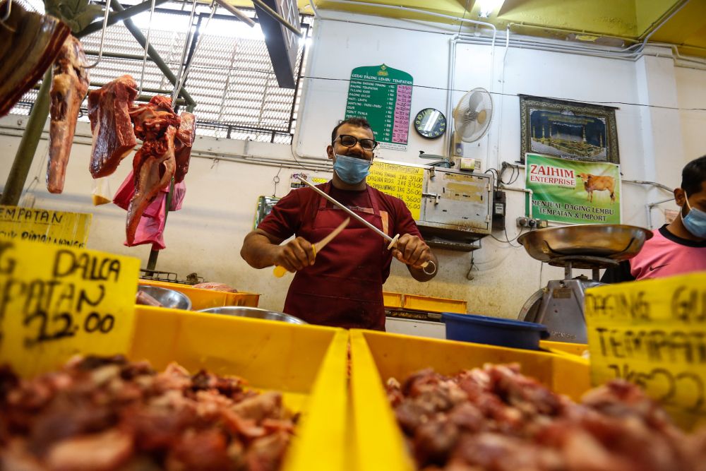 Butcher Abdul Rahman Kachi Mydin gets down to business at the Taman Tun Sardon Wet Market in Penang March 26, 2020. — Sayuti Zainudin