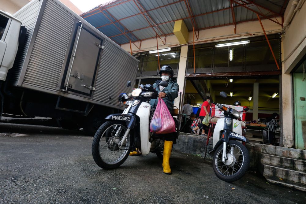 Zaihim Enterprise staff head out to make a delivery from the Taman Tun Sardon Wet Market in Penang March 26, 2020. u00e2u20acu201d Sayuti Zainudin
