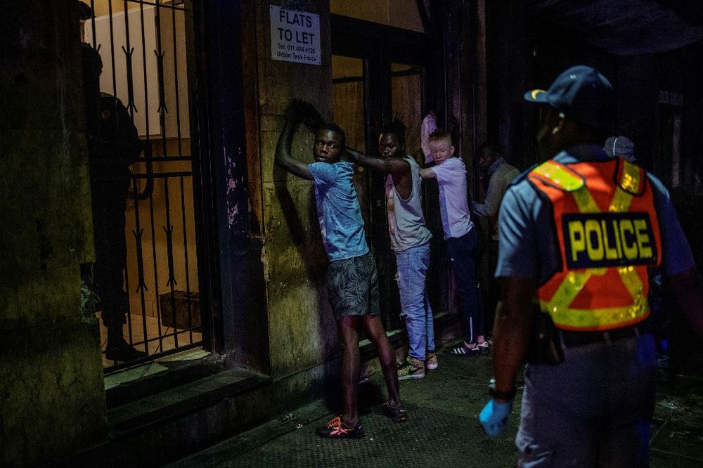 Suspects are lined up against a wall as a member of the South African Police Service wearing gloves arrests them because they defied the lockdown order during an operation in the Johannesburg CBD, March 27, 2020. u00e2u20acu201d AFP pic