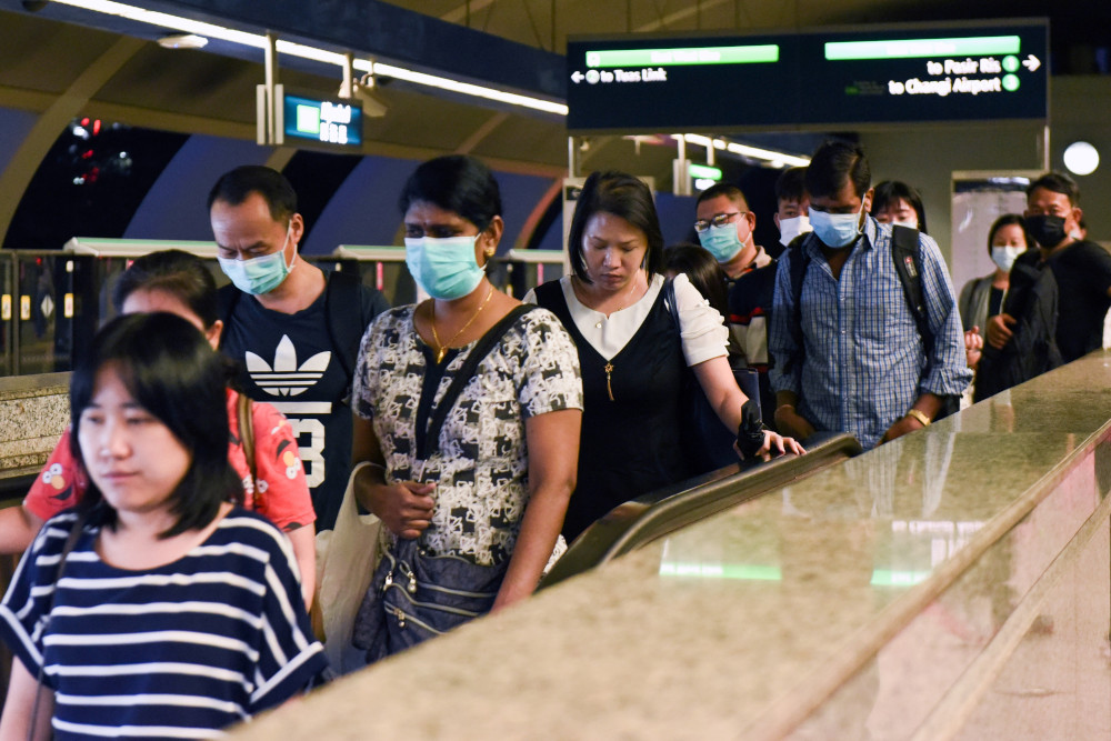 Commuters wearing face masks as a preventive measure against the Covid-19 coronavirus leave the Mass Rapid Transit train station in Singapore March 18, 2020. u00e2u20acu201d AFP pic 
