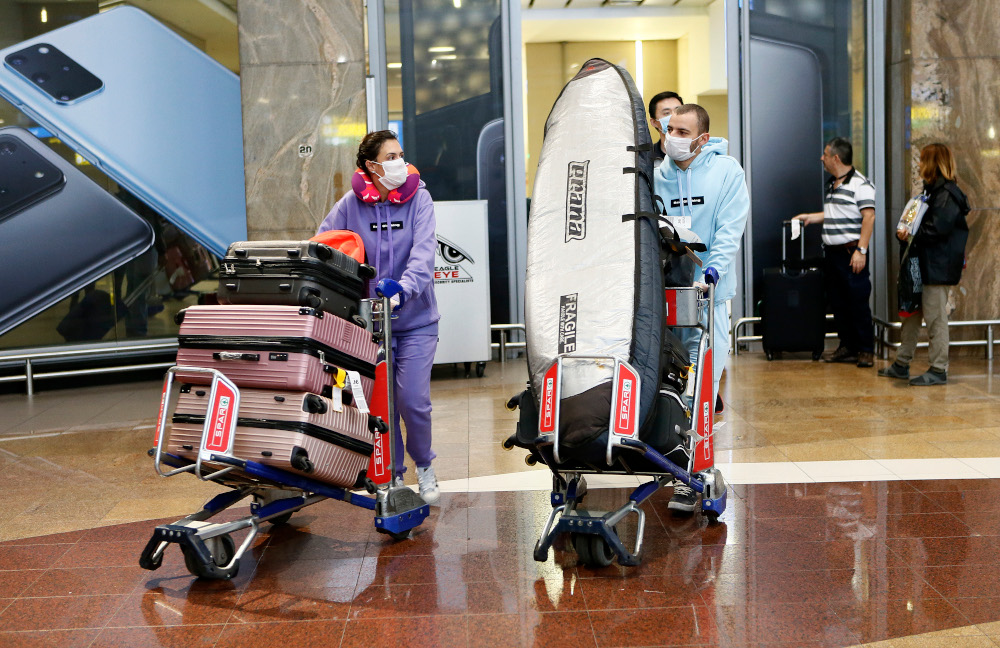 Passengers wearing protective face masks arrive from Shenzhen, China, at the OR Tambo International Airport in Johannesburg, March 2, 2020. u00e2u20acu201d AFP pic 