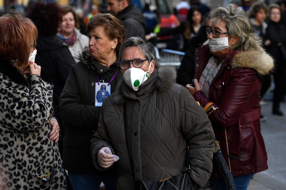 Women wearing protective masks chat after a traditional visit to the Jesus of Medinaceli church in Madrid March 6, 2020, days after the church warned against kissing or touching its famous statue of Jesus in light of the Covid-19 outbreak. u00e2u20acu201d AFP pic