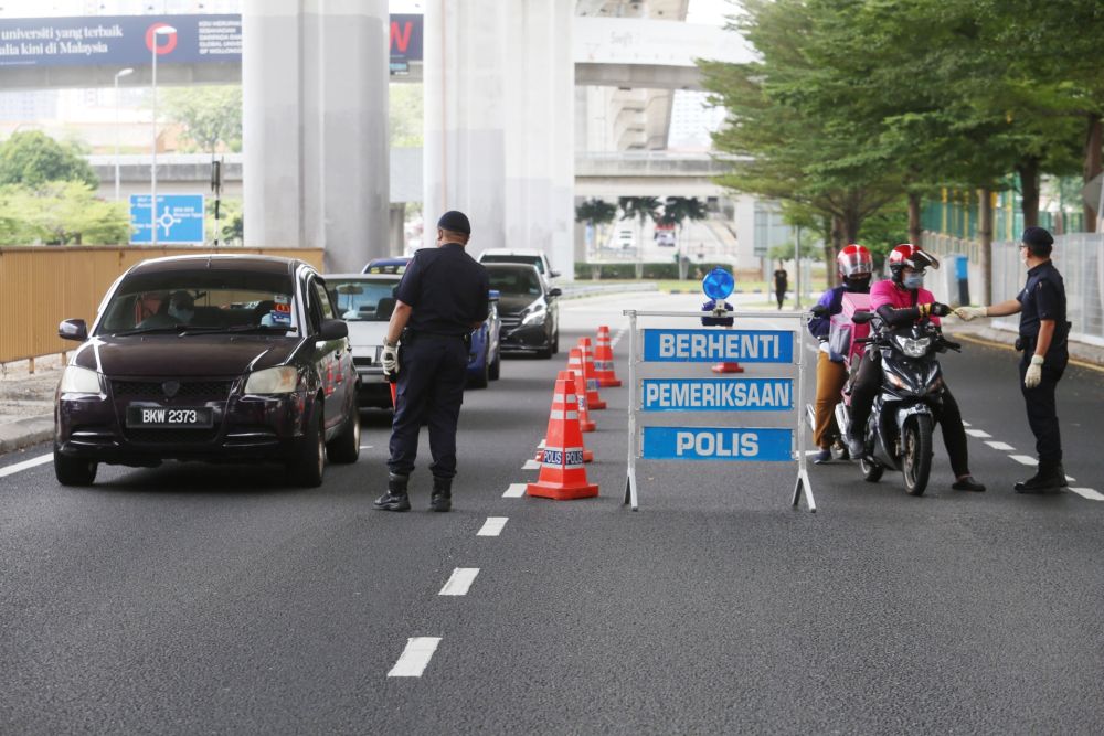 Police personnel inspect vehicles at a roadblock in Subang Jaya on Day Two of the movement control order March 19, 2020. u00e2u20acu201d Picture by Choo Choy May