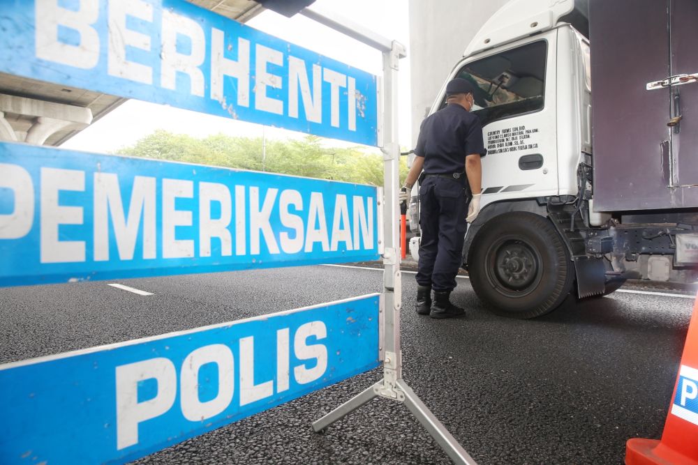 Police personnel inspects a vehicle at a roadblock in Subang Jaya on Day Two of the movement control order March 19, 2020. u00e2u20acu201d Picture by Choo Choy May