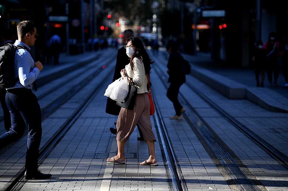 A woman wearing a face mask, amid concerns of Covid-19 threat, walks on a street in Sydney March 19, 2020. u00e2u20acu201d AFP pic