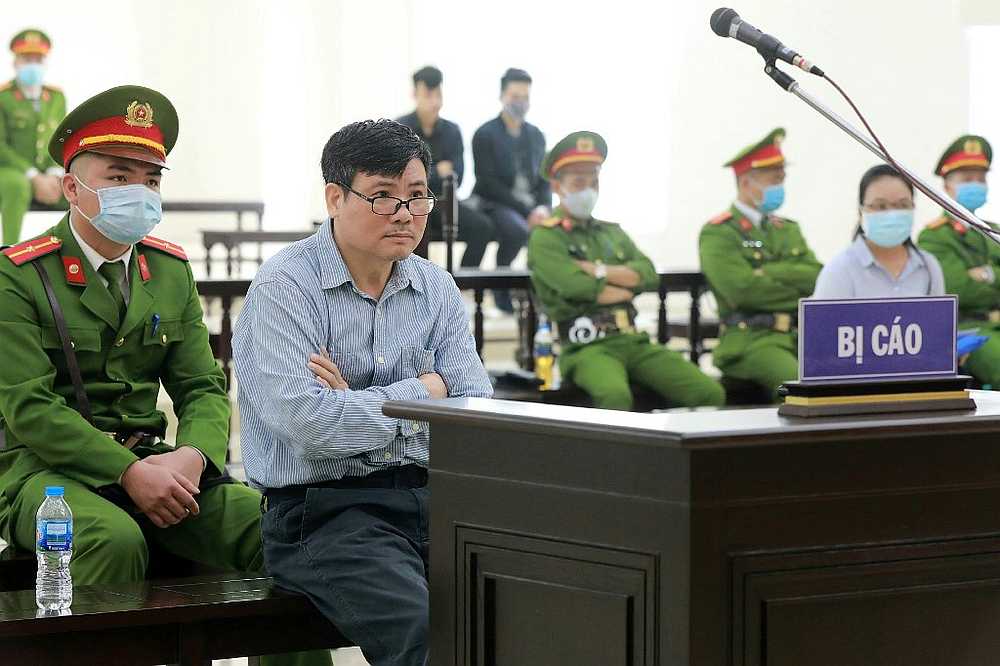 Vietnamese blogger Truong Duy Nhat (second left) sitting in a courtroom during his trial in Hanoi in this picture released March 9, 2020. u00e2u20acu201d Vietnam News Agency pic via AFP