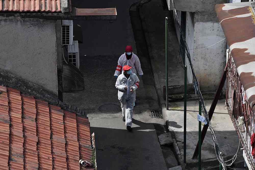 Volunteers in protective suits walk in between houses at a residential area in Wuhan, the epicentre of the novel coronavirus outbreak, Hubei province, China March 4, 2020. u00e2u20acu201d Reuters pic