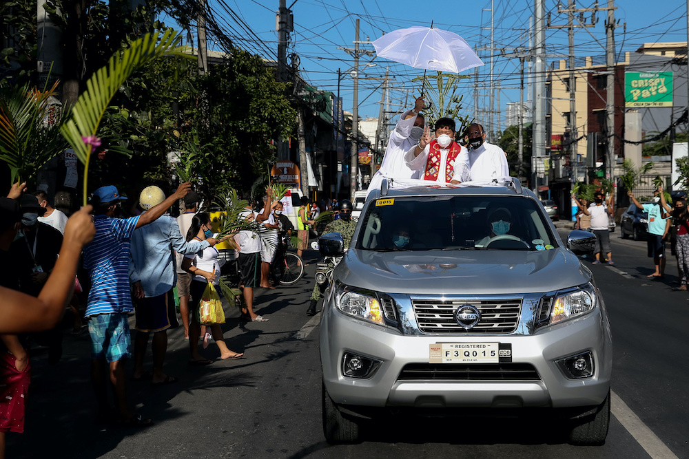 A Catholic priest stands on a pickup truck as locals wave palm fronds to be blessed in celebration of Palm Sunday amid the lockdown to contain the coronavirus disease (Covid-19), in Manila April 5, 2020. u00e2u20acu201d Reuters pic