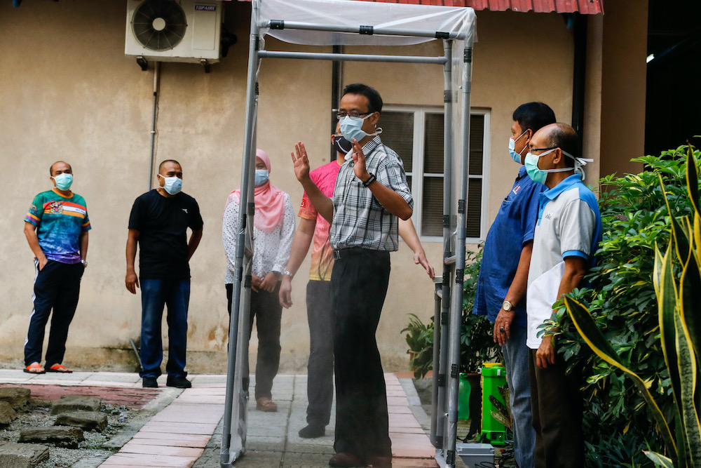 Professor Ir Mohd Fadzil Ain tests out a low-cost disinfectant chamber built by Universiti Sains Malaysia's engineering students April 6, 2020. — Picture by Sayuti Zainudin