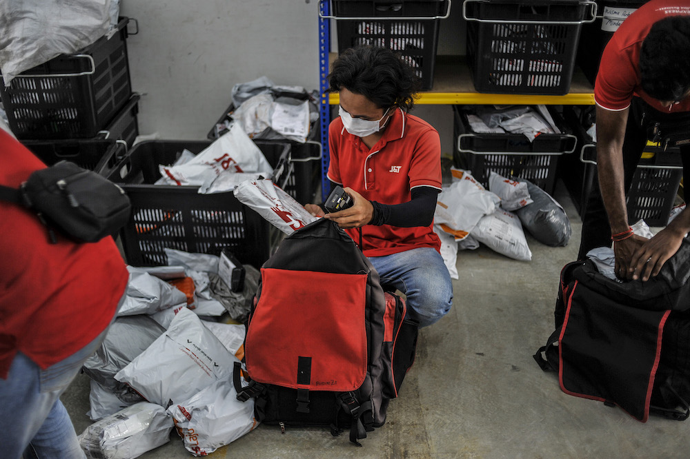 Staff of courier service company J&T Express check parcels that are ready for delivery at their warehouse in Seri Rampai April 7, 2020. u00e2u20acu201d Picture by Shafwan Zaidon