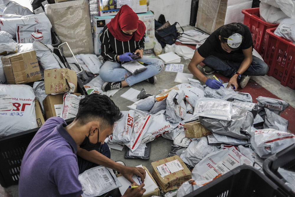 Staff of courier service company J&T Express check parcels that are ready for delivery at their warehouse in Seri Rampai April 7, 2020. u00e2u20acu201d Picture by Shafwan Zaidon