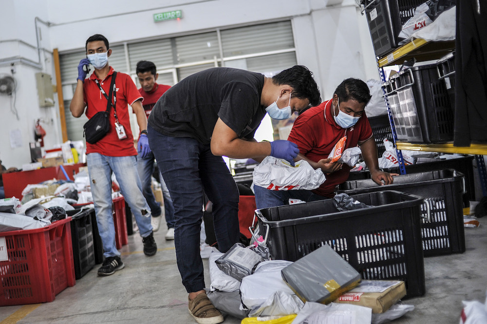 Staff of courier service company J&T Express check parcels that are ready for delivery at their warehouse in Seri Rampai April 7, 2020. u00e2u20acu201d Picture by Shafwan Zaidon
