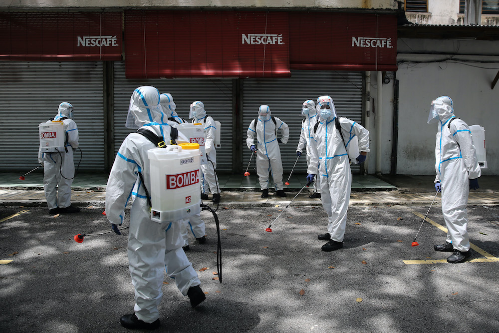 Firefighters wearing protective suits disinfect a commercial area in Section 16, Shah Alam April 7, 2020. u00e2u20acu201d Picture by Yusof Mat Isa
