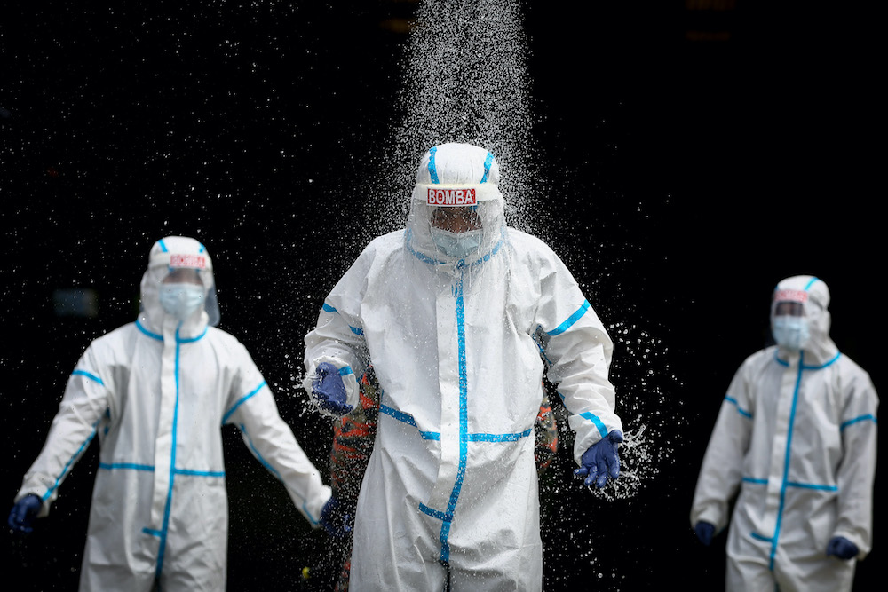 Firefighters wearing protective suits are disinfected after a disinfection operation in Section 16, Shah Alam April 7, 2020. u00e2u20acu201d Picture by Yusof Mat Isa