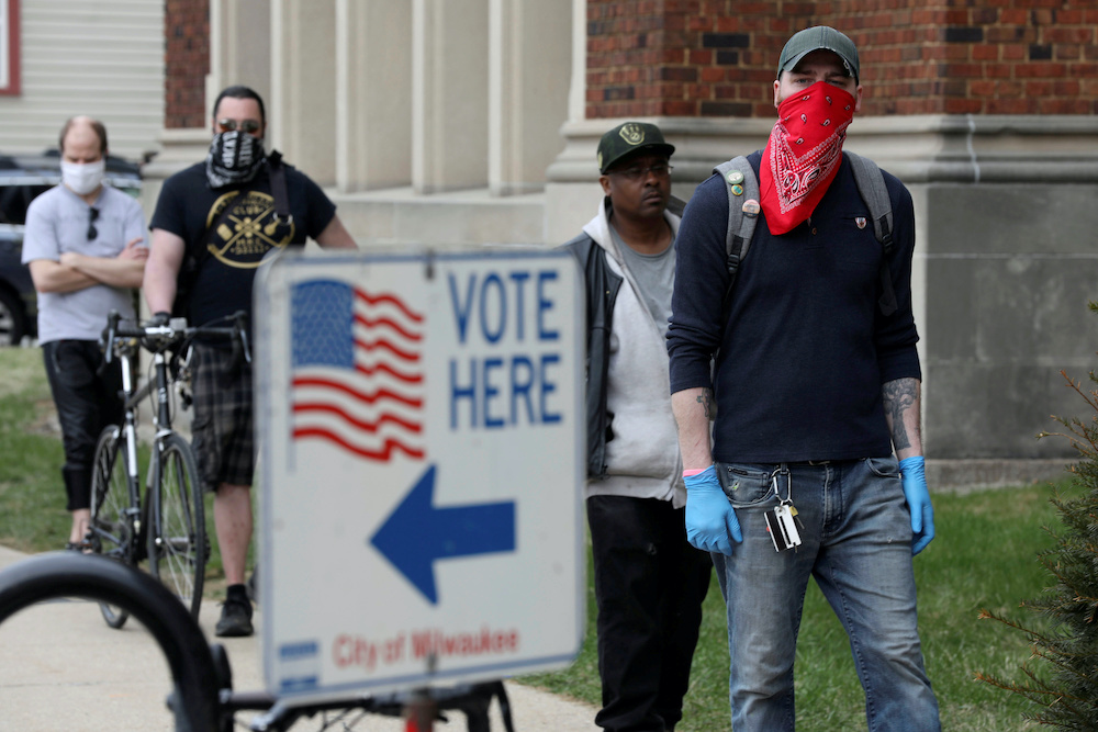 Patrick Kapple, right, waits in line outside Riverside University High School to cast a ballot during the presidential primary election held amid the coronavirus disease (Covid-19) outbreak in Milwaukee, Wisconsin April 7, 2020. u00e2u20acu201d Reuters pic