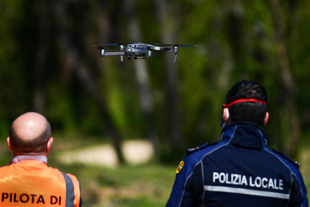 An officer of the municipal police (right), assisted by an instructor, pilots a DJI Mavic 2 Enterprise drone equipped with a thermal sensor for checking people's temperature on April 9, 2020 in Treviolo. u00e2u20acu201d AFP pic