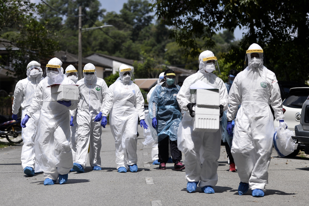 Health workers in protective suits are seen after conducting Covid-19 testing at Lorong Jalan Puyuh, Shah Alam April 12, 2020. u00e2u20acu201d Picture by Miera Zulyana