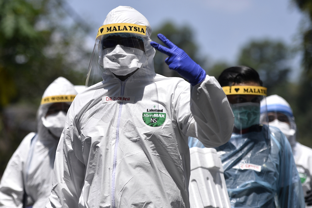 Health workers in protective suits are seen after conducting Covid-19 testing at Lorong Jalan Puyuh, Shah Alam April 12, 2020. u00e2u20acu201d Picture by Miera Zulyana