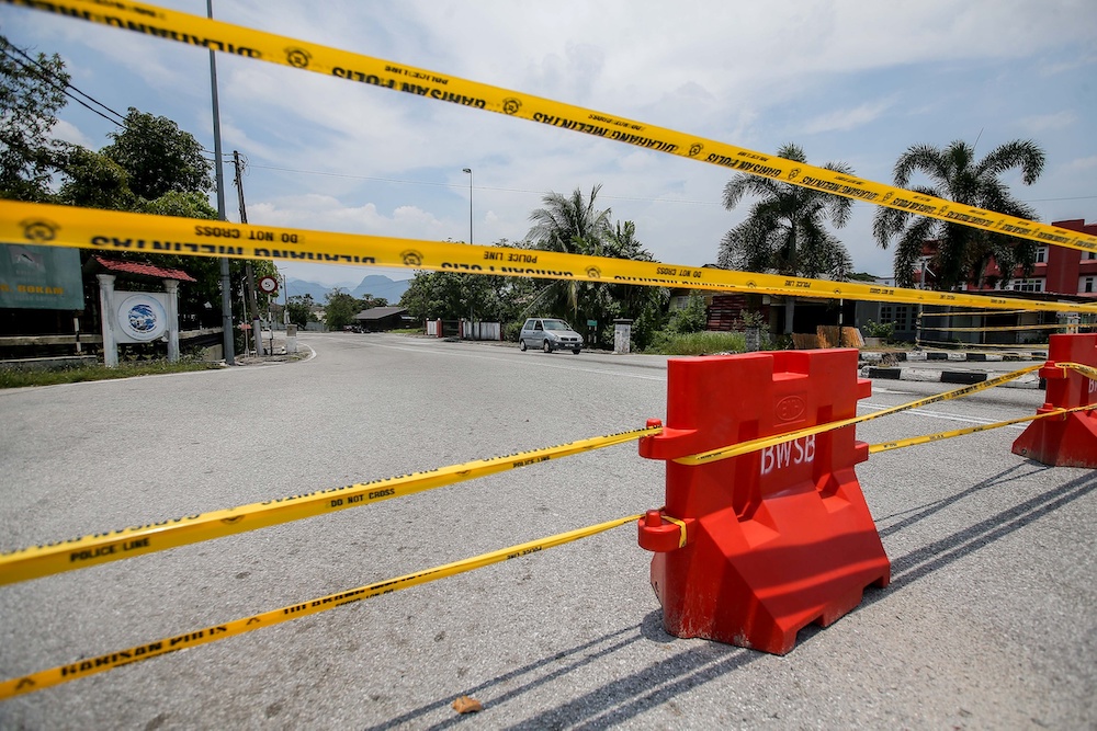 As the country continues to battle the Covid-19 pandemic, police are closing more roads to ensure the people adhere to the movement control order. In Ipoh, the entrance to Kampung Sungai Rokam is closed to traffic. u00e2u20acu201d Picture by Farhan Najib