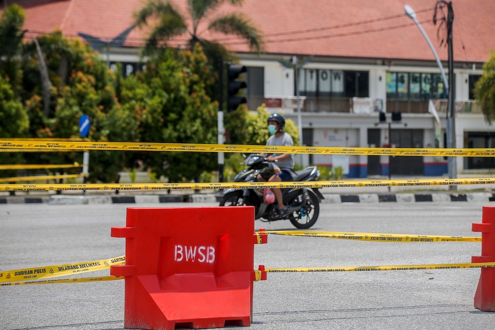 As the country continues to battle the Covid-19 pandemic, police are closing more roads to ensure the people adhere to the movement control order. In Ipoh, the entrance to Kampung Sungai Rokam is closed to traffic. u00e2u20acu201d Picture by Farhan Najib