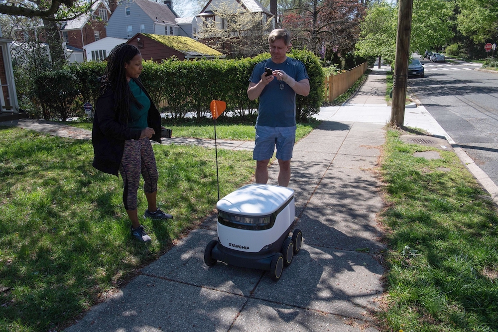 Kimmo Kartano uses his smartphone to open a food delivery robot from the Broad Branch Market grocery store. u00e2u20acu201d AFP pic