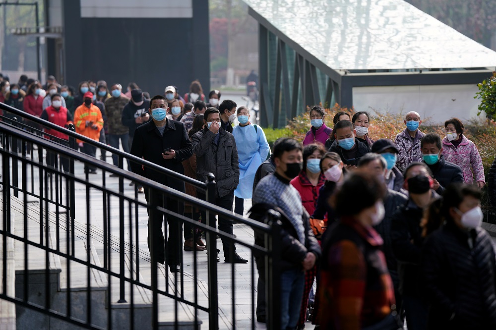 People wearing face masks line up to enter a supermarket in Wuhan April 1, 2020. u00e2u20acu201d Reuters pic