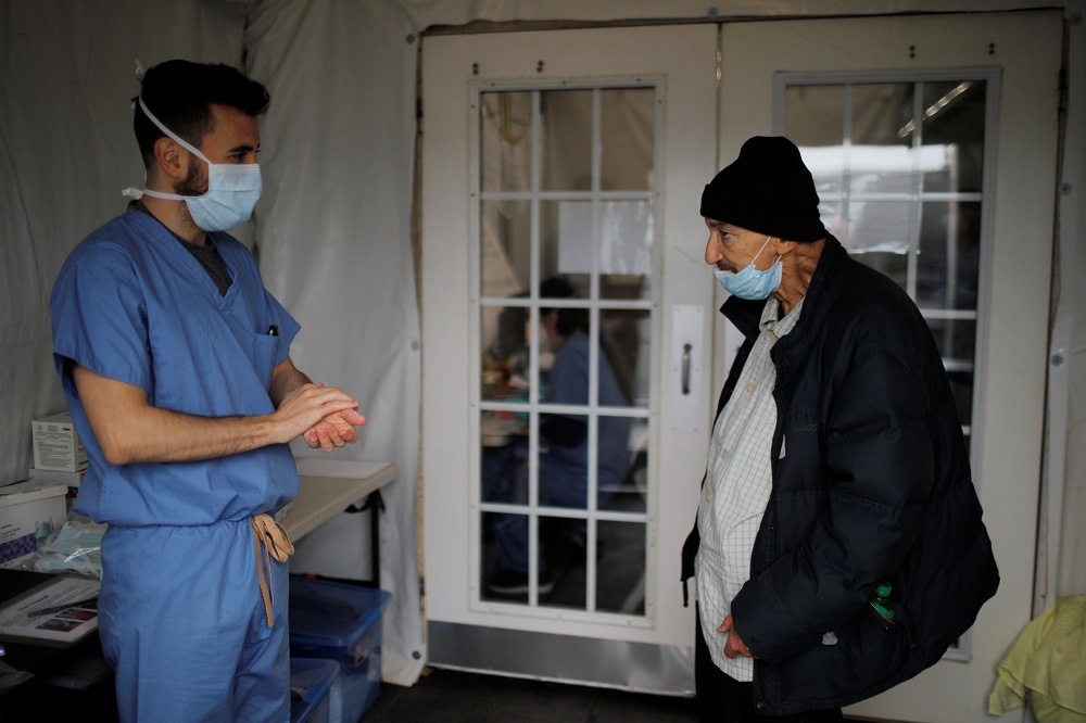 A homeless man talks to Case Manager Mike Mayer outside a quarantine tent run by Boston Health Care for the Homeless in Boston April 2, 2020. u00e2u20acu201d Reuters pic