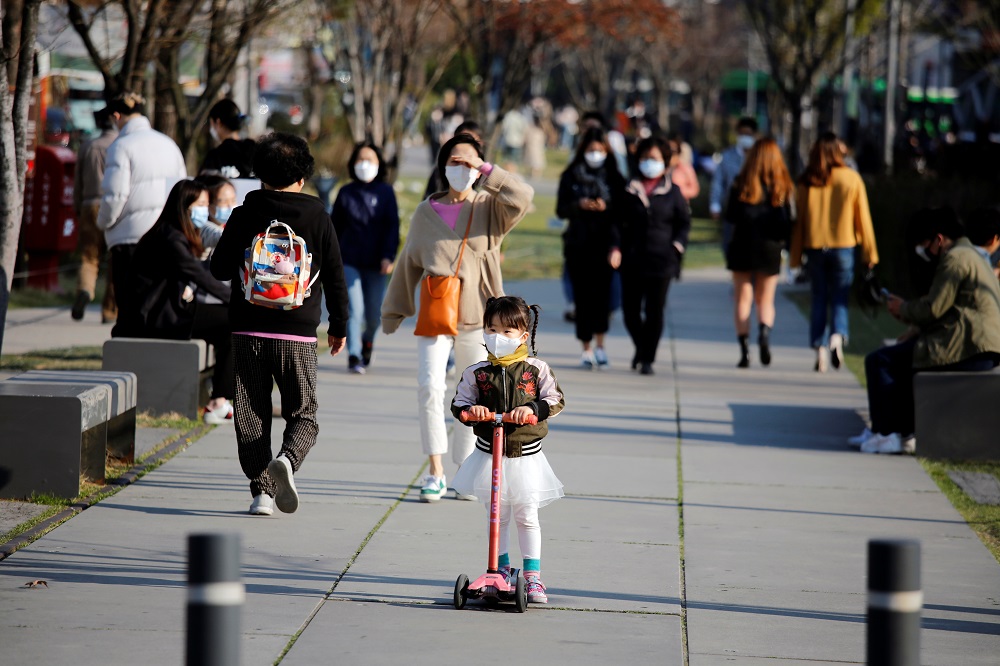 A girl wearing a protective face mask to prevent contracting the coronavirus disease (Covid-19) rides a toy kick scooter at a park in Seoul April 3, 2020. u00e2u20acu201d Reuters pic