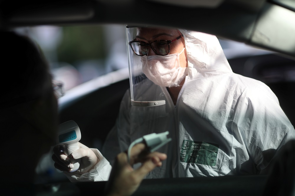 A nurse measures the temperature and oxygen level of the blood of a man during drive-thru triage to identify people with coronavirus disease symptoms in Guarulhos, Sao Paulo state, Brazil April 3, 2020. u00c2u00acu00e2u20acu201d Reuters pic